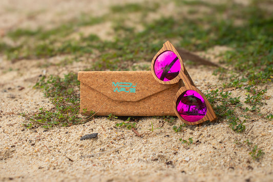 MoovWave BlooWave Blush wooden floatable polarized sunglasses with pink mirrored lenses on sandy beach with cork case