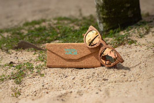 MoovWave BlooWave Sundown wooden floatable polarized sunglasses with gold mirrored lenses on sandy beach with cork case