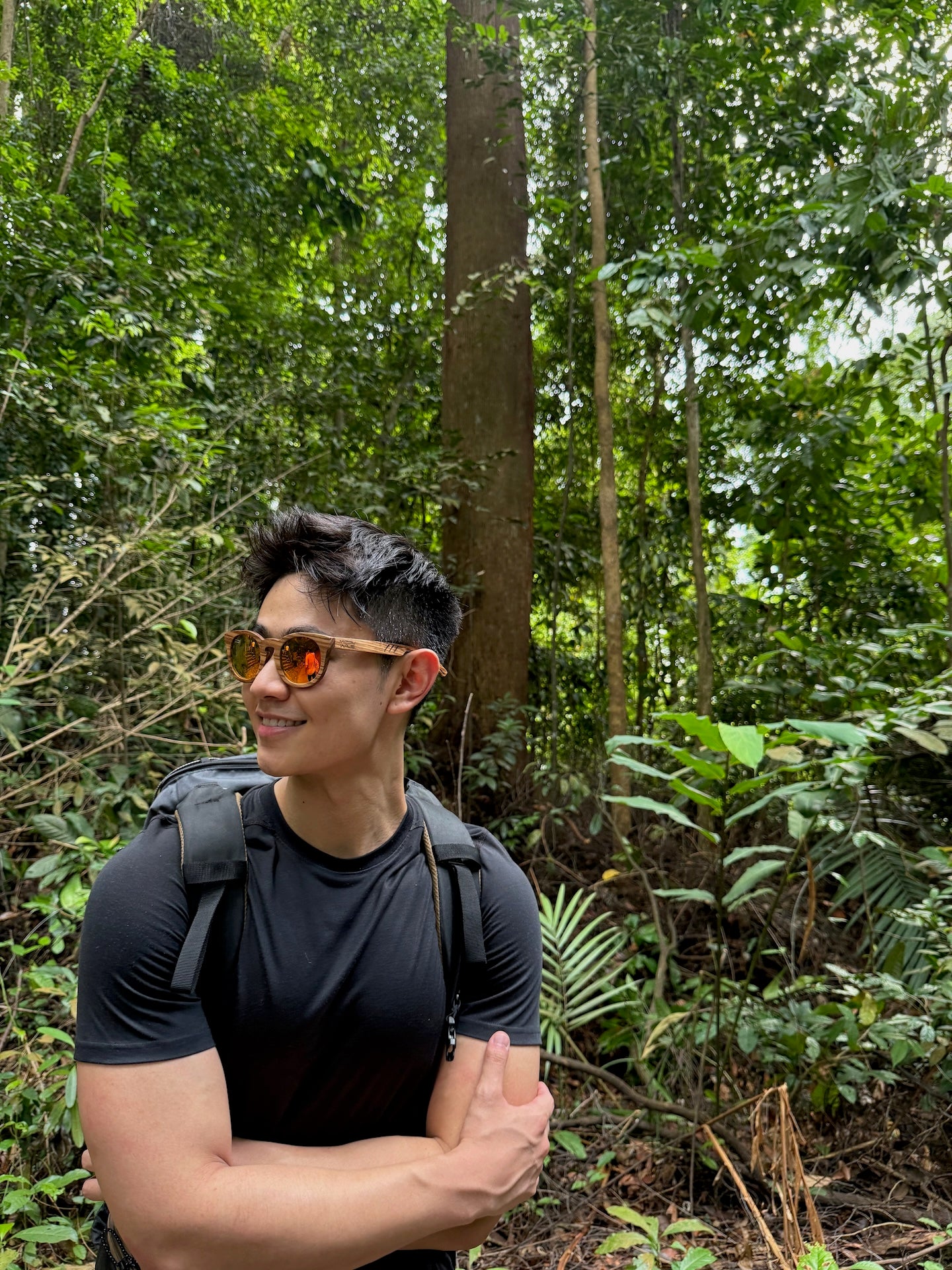 Asian man wearing MoovWave Ember red wooden sunglasses while hiking at Bukit Timah Nature Reserve, floatable polarized Asian fit sunglasses for outdoor use in Singapore